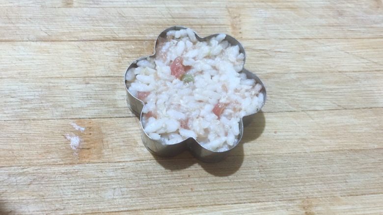 黄金甲米饭猪肉饼,准备一个自己喜欢的模具,把搅拌好的米饭放到模具里。