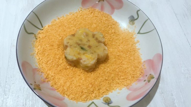 黄金甲米饭猪肉饼,把沾满蛋液的米饭饼放到准备好的面包糠里,均匀的沾满面包糠。