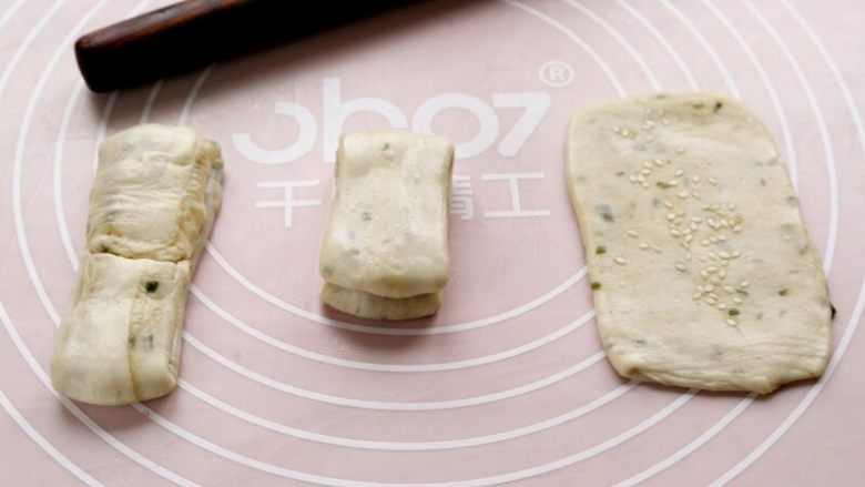 油酥烧饼,10.取一份长条两头往中间折,轻轻地擀开;再对折,有时间可饧上10分钟;没时间在表面撒点芝麻,直接擀开。