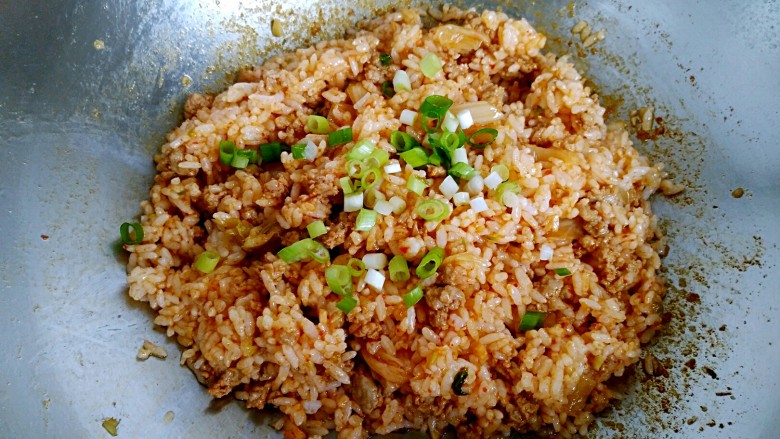 辣白菜肉末炒米饭,最后撒入剩下的葱花,翻炒均匀即可关火出锅。