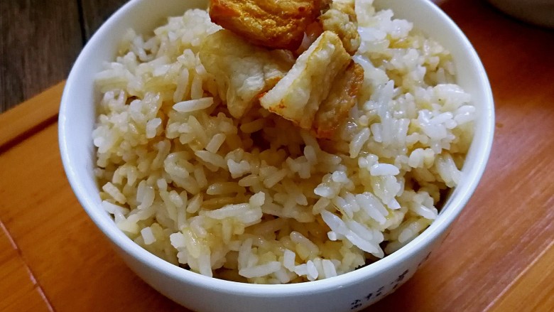 古早味猪油拌饭,盛起拌炒好的米饭,放几块油渣在上面。