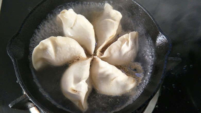 抱蛋煎饺,小火煎一会后倒入抹过饺子一半的<a style='color:red;display:inline-block;' href='/shicai/ 156925'>水</a>,中火煎煮。
