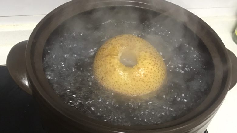 【不一样的冰糖雪梨】止咳良方,盖上盖子大火烧开,我是为了拍照才把盖子掀起来的,大火烧开后转小火慢慢炖,我一般都是晚上炖两个小时,早上起来再炖三四个小时,具体时间根据汤的浓度