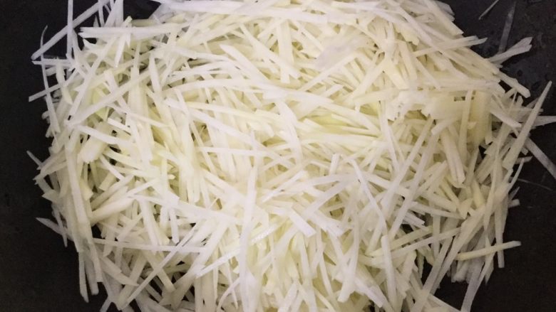 酸辣土豆丝,倒入土豆丝。倒入土豆丝。