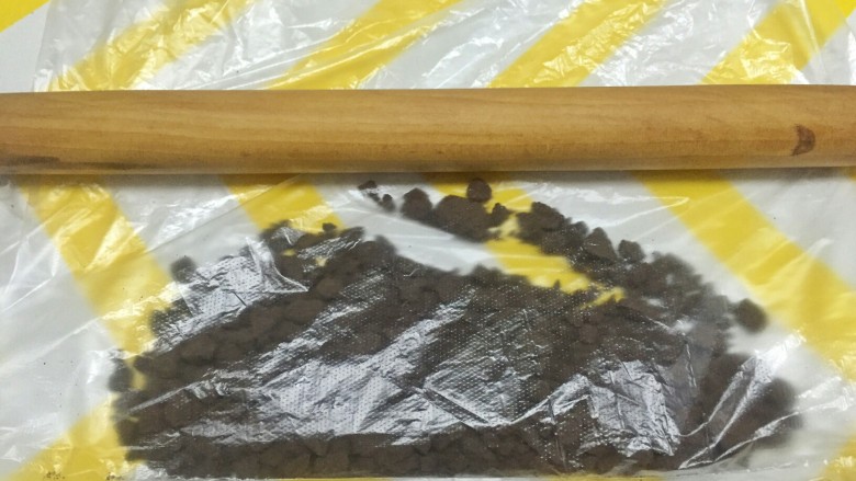奥利奥竹炭卷,取适量奥利奥碎放入保鲜袋中,借助擀面杖碾压成沫,备用。
