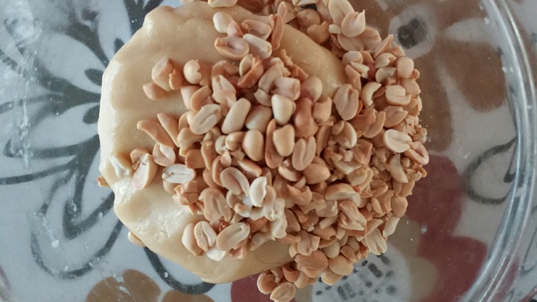 葡萄干花生酥(低糖低油版),将花生仁倒入面团上
