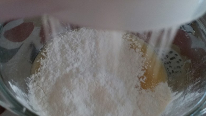 葡萄干花生酥(低糖低油版),低筋粉和泡打粉过筛在蛋液碗中