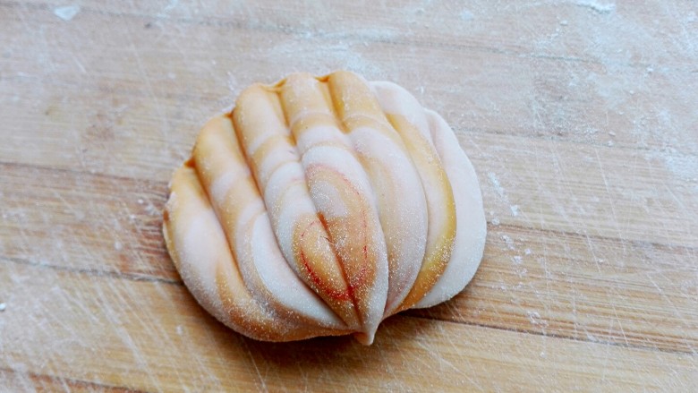 花样包子,也可以做成小贝壳,两种颜色面团摞起来擀成长条,卷起来,擀成椭圆形,用筷子压出纹路,对折,整理一下即可