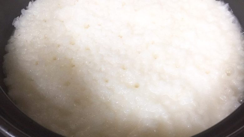 广式腊味煲仔饭,大火烧开转小火煮至米饭出现很多气眼,这时的米饭大概有七成熟了,可以排入腊肠腊肉了