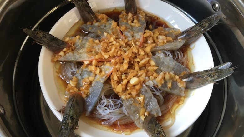 蒜蓉粉丝蒸大虾,淋到盘子里,水烧开蒸五六分钟,蒸久了肉不嫩