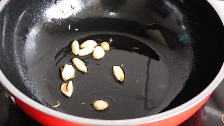 香辣鹌鹑蛋,炒锅放油烧热,蒜瓣爆炒
