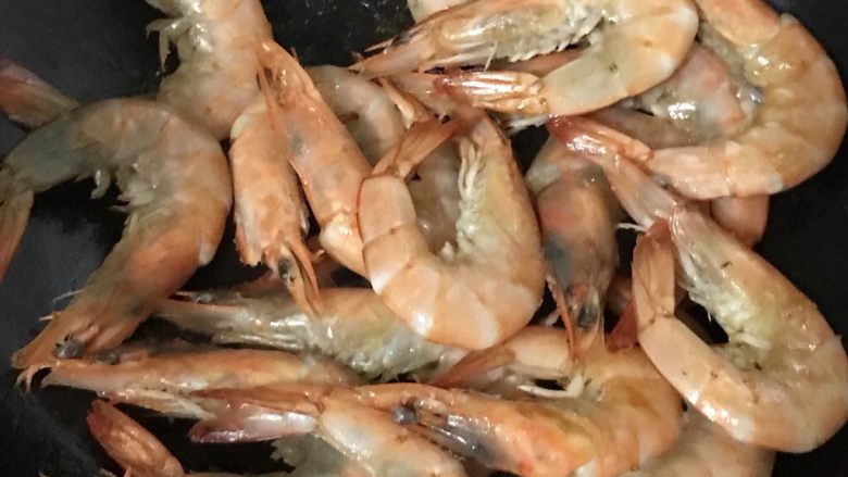红烧虾,中火热㶽,放入1茶匙食用油,把虾两面煎成红色,时间不要长,一面变红翻转另一面。