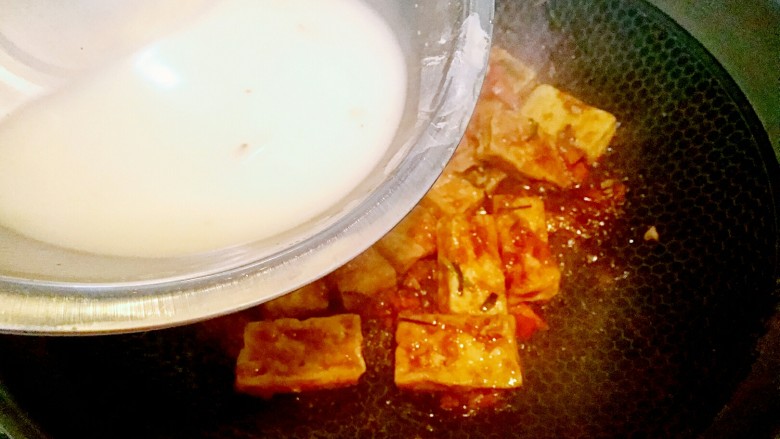 糖醋豆腐,翻炒均匀后,用淀粉兑水勾芡汁再倒入锅中