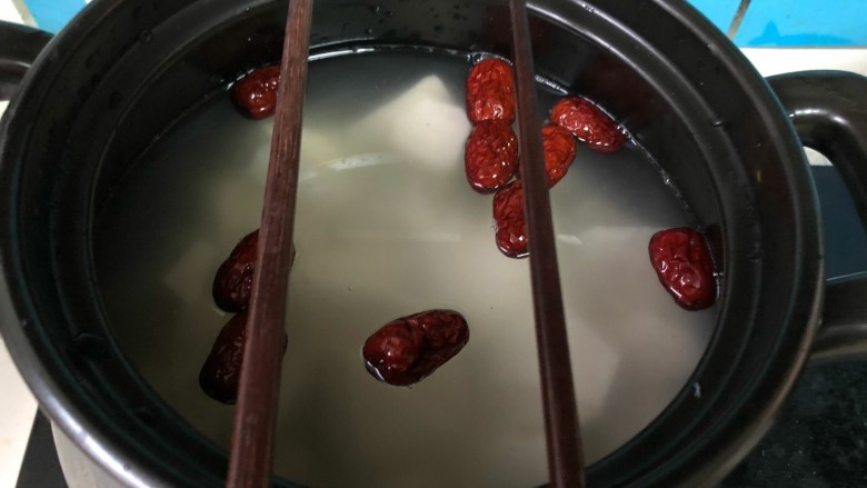 健康美味红薯绿豆大枣粥,取一双筷子,搭在砂锅口,如图所示。
