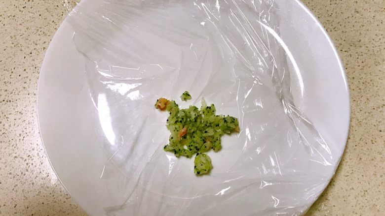 虾仁西蓝花饭团,取一块保鲜膜,放入一勺虾仁西蓝花米饭
