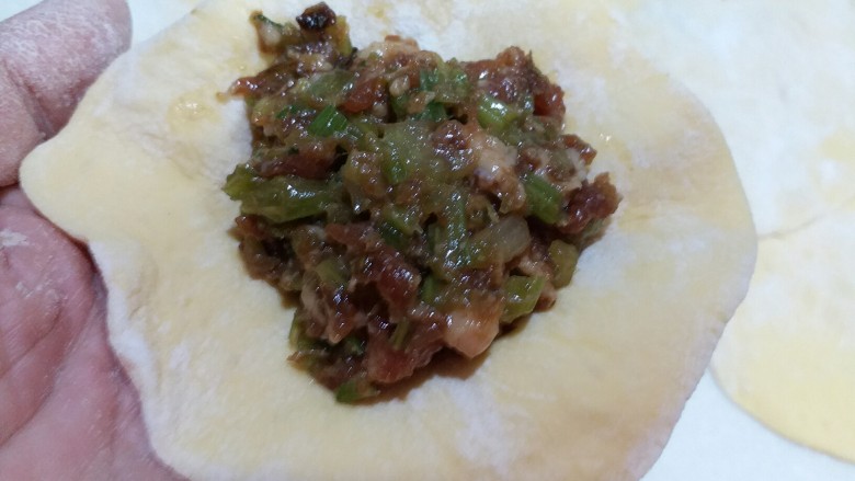 南瓜芹菜肉包子,将馅料放在包子皮的中央,开始包包子