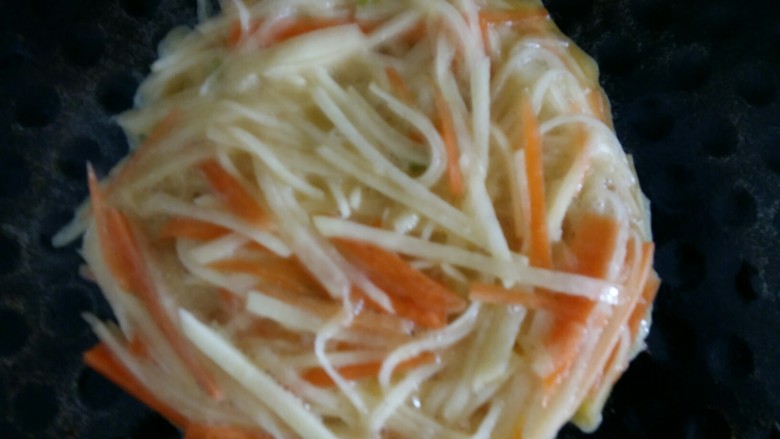 双丝饼,电饼铛刷油,倒入一勺混合后的土豆丝,边缘整理一下,尽量圆一些,上面压平。