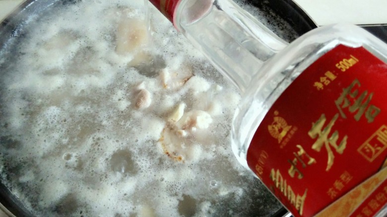 黄豆炖猪蹄,第一层泡沫撇出去,又出来许多泡沫,倒入约30克曲酒,用汤勺搅拌一下。