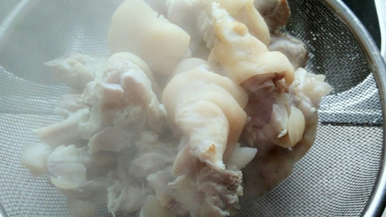 黄豆炖猪蹄,将猪蹄捞出,用温水洗洗,倒入漏盆中。