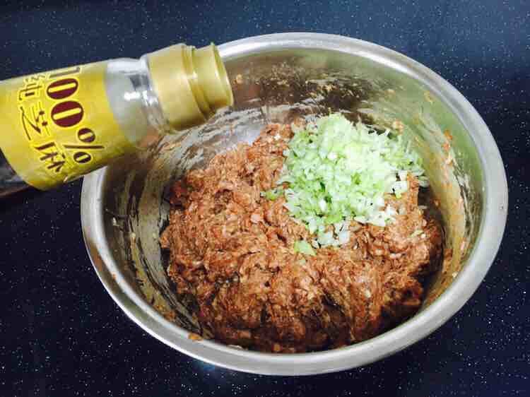 家乡风味饺子 三鲜馅饺子,最后放入葱花,在葱花上放约20g左右的香油,先用香油把葱花拌匀,再将葱花与肉馅充分调匀,即朝一个方向搅拌均匀,大约搅拌100下左右。 先用油裹住葱花的目的是防止葱汁外溢,造成肉馅葱味过重。猪肉馅调好了备用。