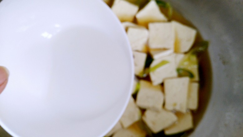 家常炖豆腐(健康无油版),大约五分钟后,倒入调好的淀粉,翻炒均匀使汤汁粘稠即可关火。