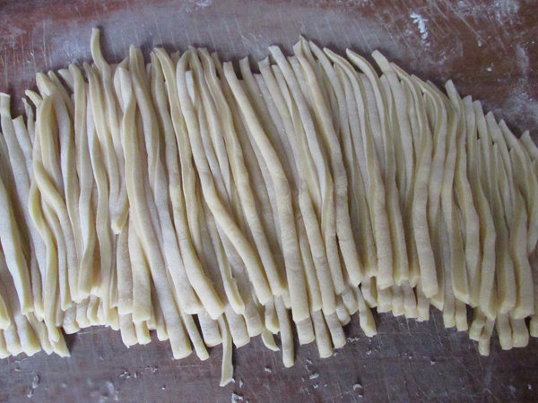 牛轧糖沙琪玛,擀成厚度2毫米的片,再切成宽度2毫米的条,切的时候也要撒少许玉米淀粉放沾
