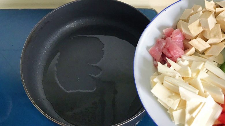 彩椒滑口白玉菇,热锅冷油,把盘里的茭白、豆干、肉片先倒进锅里翻炒