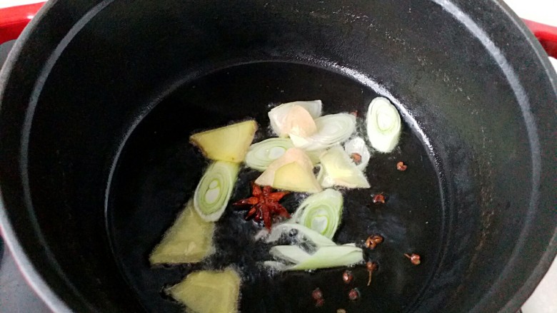 鸭腿黑蒜酸萝卜,倒掉焯鸭肉的汤水,洗干净锅再坐炉灶上烧热,放入少量玉米油,将葱姜八角花椒粒放入煸出香味