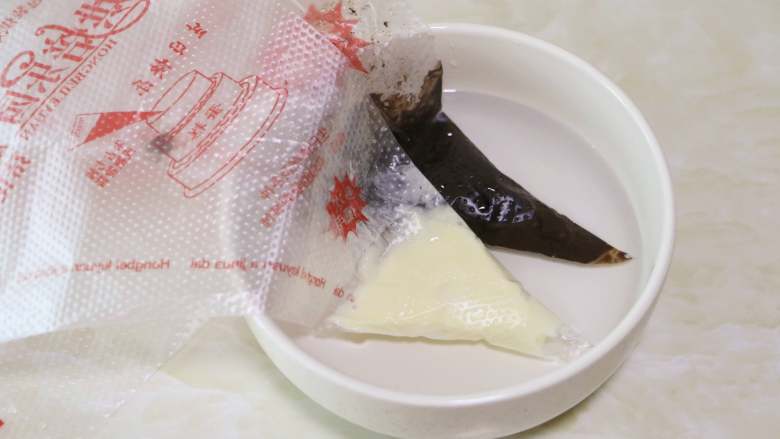 轻松熊小面包,烤好出炉,待面包放凉后再进行装饰:黑、白巧克力分别装入裱花袋中隔温水融化