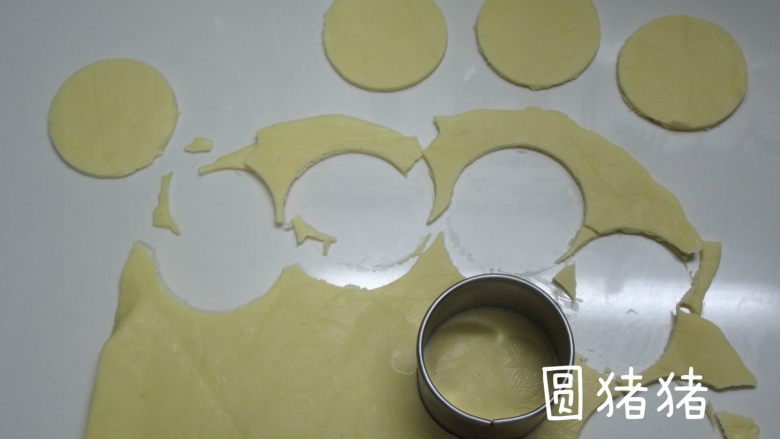 南瓜鬼脸夹心饼干,约半小时后,将面片取出,用圆形的切割器,或是其它圆形的模具,将面团切割成圆片形。将切割的边沿做为南瓜的柄贴在圆形上方。