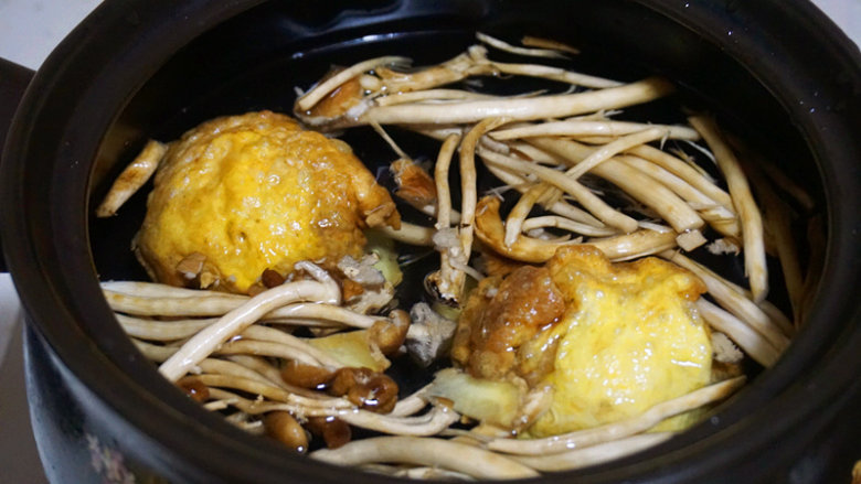 蛋包肉丸菇香汤,水开后,将炸好的肉丸下入锅内,大火烧开转为小火,文火煲1个小时