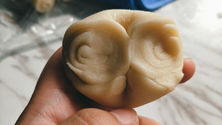 苏式鲜肉月饼,取一块面团用拇指按压中间位置,将两边向中间压平。