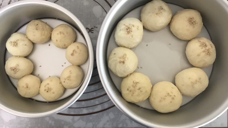 花环汉堡,醒发好的面团放进戚风模具中。大面团放8寸的,小面团放6寸的,撒上芝麻。放入烤箱,开发酵档38度,放一杯热水大致两倍大