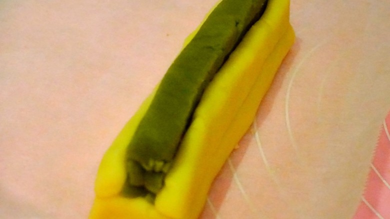 🐰抹茶兔子饼干(可爱美味又简单),时间到了后就取出来准备做兔兔吧~
1⃣从抹茶面皮处切出三条大约1cm宽的面条条,依次叠放在兔兔脸面团上,注意要正中摆放哟
2⃣然后将两条小耳朵放在抹茶面团的两侧
3⃣最后用剩余的抹茶面皮包裹住兔兔,(包裹后的样子见下图)
⭐️注意⭐️每一步最好都用油纸包住整体轻轻按压一下,这样就不会容易出现缝隙
⭐️⭐️⭐️以上步骤全部完成后先冷冻30分钟再冷藏20分钟