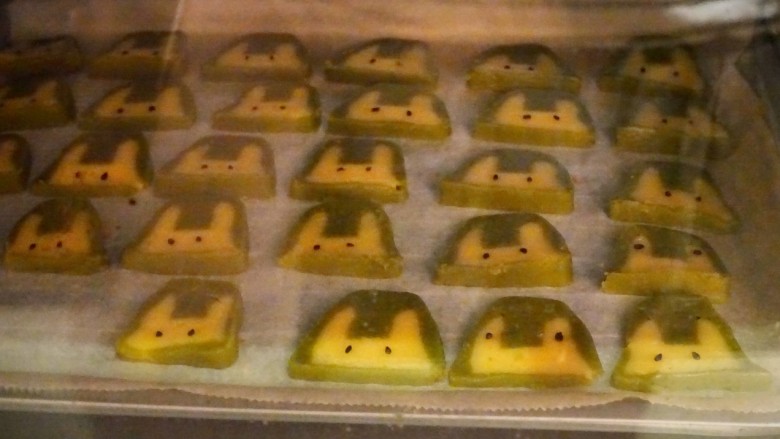 🐰抹茶兔子饼干(可爱美味又简单),把兔兔依次放入垫好油纸的烤盘中,每只兔子脸上都放两粒芝麻当做眼睛👀~
我放的比较随意感觉不一样才比较可爱哈哈
(有两只像青蛙一样的是熊先生干的😂)