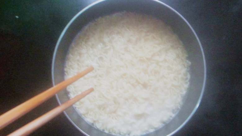 自制火鸡面,开水入锅煮1分钟,煮至方面松散,用筷子捞出