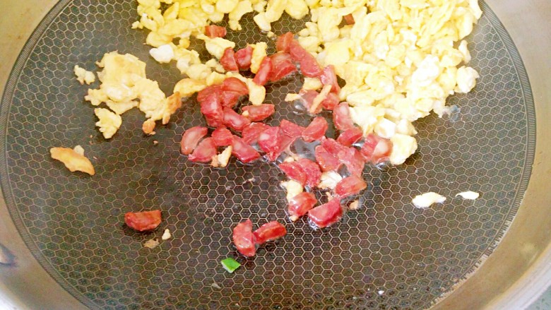 蛋炒饭,鸡蛋炒好后,把它拨到锅的边沿,再下<a style='color:red;display:inline-block;' href='/shicai/ 4536'>腊肠</a>丁翻炒出油。