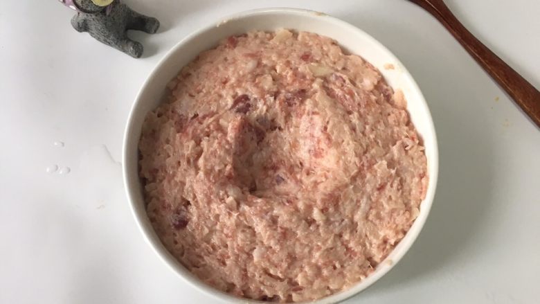 宝宝辅食之莲藕肉饼蒸蛋,放入盘中,轻轻推开,让肉馅布满盘底。中间挖个小坑
