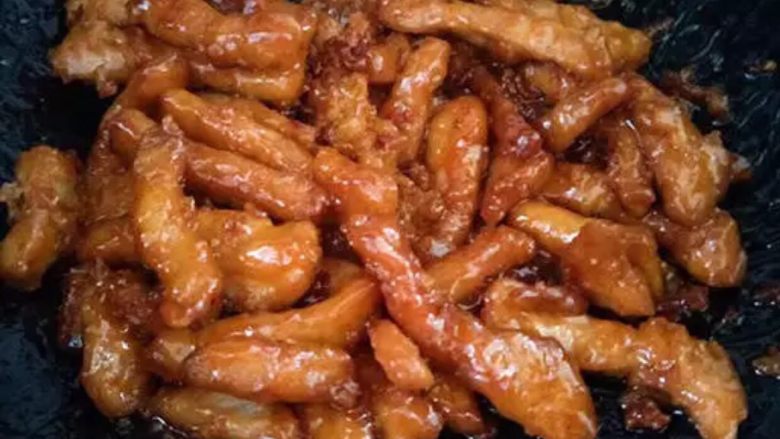 糖醋里脊,把炸好的里脊肉放入料汁里面滚一滚,蘸均匀就可以出锅了