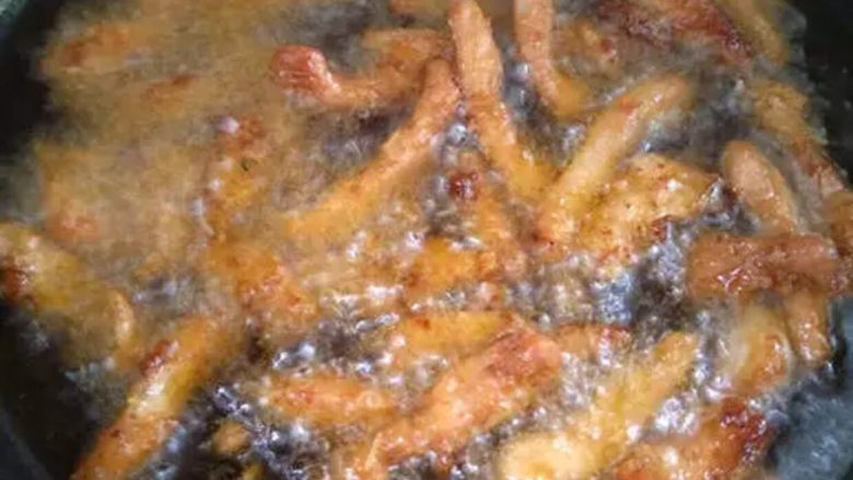 糖醋里脊,锅内热油,将里脊肉下锅中炸至表面微微变黄,捞出控油,将炸好的肉,再倒入锅内复炸,待表面呈金黄色时捞出控油