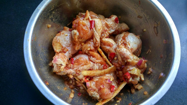 香辣鸡翅根(烤箱版),戴上一次性手套,将调料和鸡翅根拌匀,并给翅根按揉10分钟。