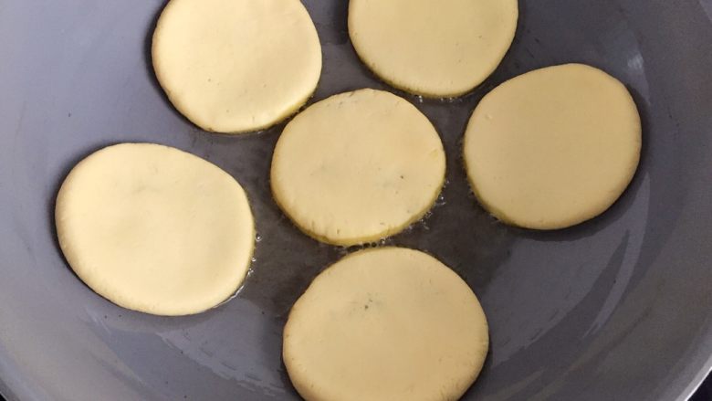 香煎花生南瓜饼,不粘锅里倒入适量油烧热,放入做好的南瓜饼,中小火慢煎,不要着急翻,等到可以轻轻晃动的时候翻面煎。