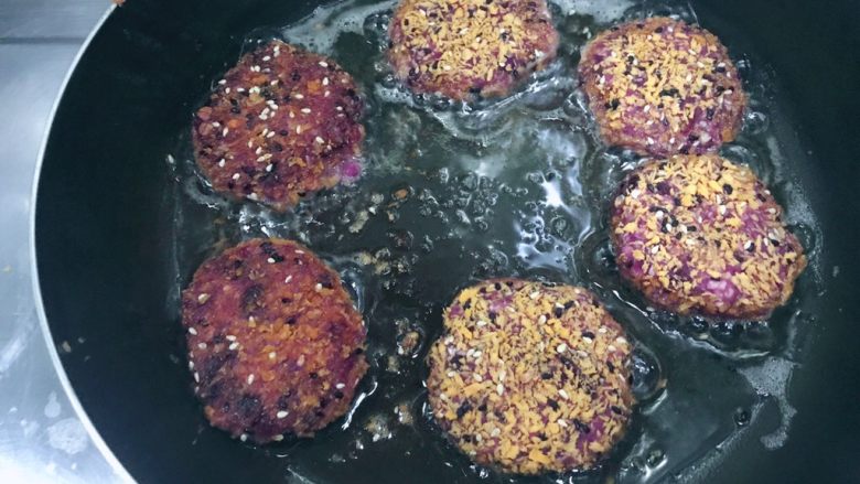 万紫千红香蕉紫薯燕麦饼,把沾满面包糠的小饼放入锅内,小火煎!