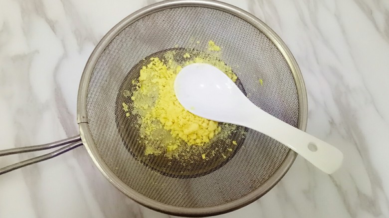 玛格丽特饼干,鸡蛋凉水下锅,水沸后煮8分钟,捞出放凉水冷却,取蛋黄在筛子上过筛,用勺子按压使蛋黄通过筛网,成为蛋黄细末