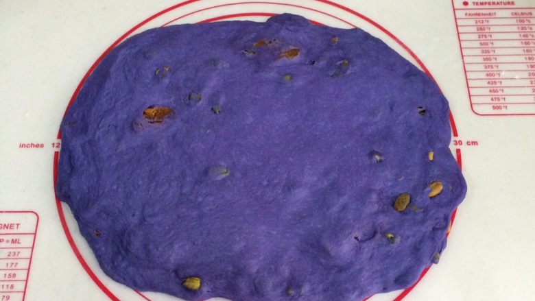全麦星空面包,取出面团,放在垫子上按压排气,提起四个角。