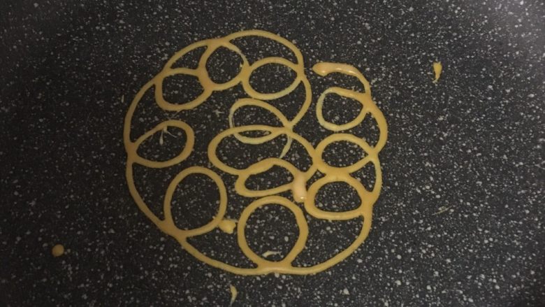 宝宝辅食之网格蛋卷,把裱花袋剪开一个细细的小口。热锅开小火,不加油,一圈一圈,从里向外挤成蛋饼即可。