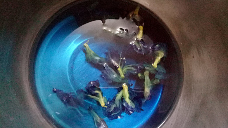 海洋蛋糕,取150克清水和30克砂糖放入小锅中加热煮开后关火放入蝶豆花泡一会,水会变成蓝色。在水温低于50度的时候把泡软的吉利丁片放入搅匀。
