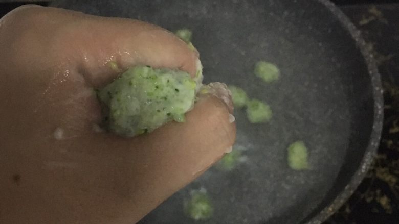 翡翠虾球,起锅烧沸水,双手洗净,沾点温水。从虎口挤出一个个虾球,把挤好的虾球放入锅中,全程小火微沸。
