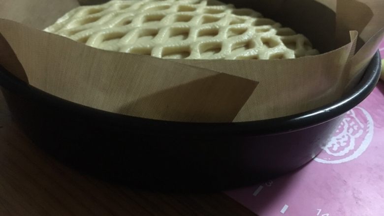 网纹果酱夹心面包,移入8寸的烤盘,为防粘又垫了油布,如是不沾烤盘就不必垫了