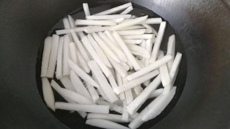 牛肉筷子萝卜,锅中加适量水,放入萝卜条,调入少许盐和食用油;
